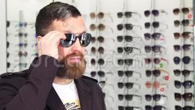 在眼镜店试戴太阳镜的成熟男人